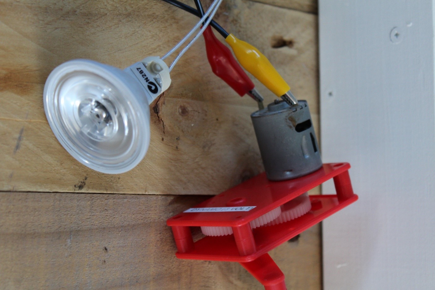 IMAGE: Hand powered dynamo connected to an LED light. Turning the arm of the dynamo generates electricity inside the little ‘motor’ (grey coloured cylindrical motor). The electricity from the dynamo can light up the LED light.